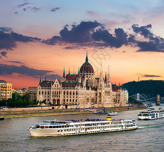 布达佩斯日落时的旅游船和匈牙利议会图片