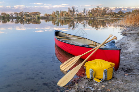 在科罗拉多落下风景的湖岸上有木桨和干袋的红色独木舟在科罗拉多落下风景图片