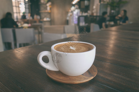 在温暖的自助食堂木桌上一杯咖啡拿铁图片