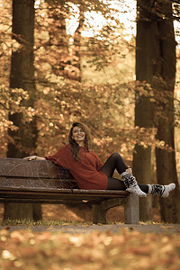 自然户外休闲风景概念红发女郎坐在长椅上年轻优雅女孩坐在秋天公园图片