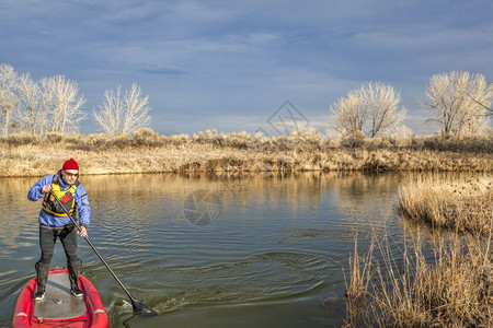 男子在科罗拉多州的湖边划桨板图片