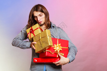 假日圣诞节冬季和特殊场合年轻英俊的时尚男子拿着许多礼物盒带着许多礼物盒的人背景图片
