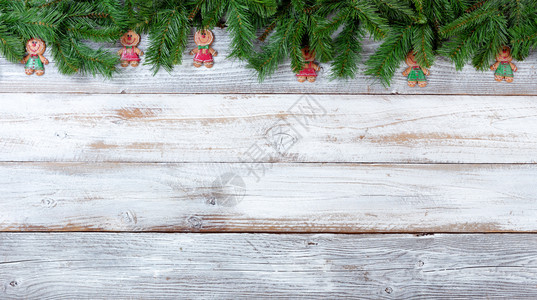 圣诞长绿树的顶端边界白旧木头上的饼干装饰图片