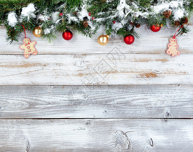 圣诞绿树枝和其他节日装饰品在白锈木上图片