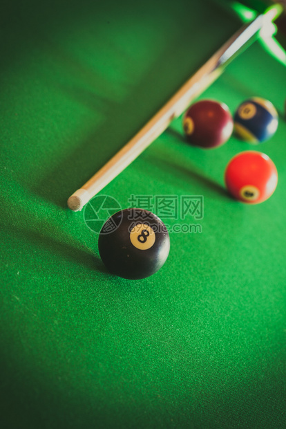 Billiard球和杆粘在绿色桌上池球游戏史努克和坚持在台桌上图片