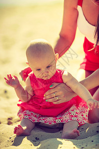 坐在沙滩上的小婴儿玩得开心图片
