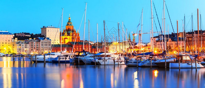 芬兰赫尔辛基老城旧港码头和乌斯彭基东正教堂的夏季夜全景图片
