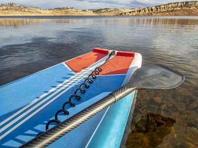 冬季在山湖上起立用桨和安全系绳挂起桨板图片
