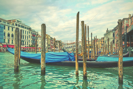 威尼斯Rialto桥附近的大运河与意利的Gondolas系住图片
