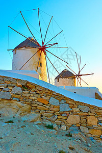 希腊米科诺斯岛日落时的旧风车图片