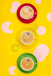 咖啡杯和黄纸背景的彩色圈平铺的板纸咖啡杯和黄纸背面的彩色圈图片