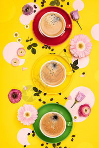 咖啡杯和黄纸背景的彩色圈平铺的板纸咖啡杯和黄纸背面的彩色圈图片