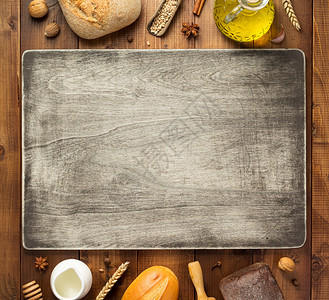 木制表格背景顶视图上的面包和制成材料图片