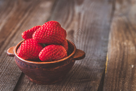 草莓奶茶木制桌上一碗新鲜草莓背景