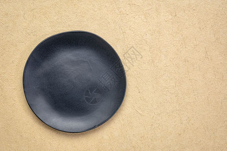 黑色瓷板在天然浅棕手工制HuunMayan纸上有非正常边缘复制空间的黑瓷板图片