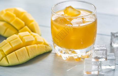 木制桌上的芒果汁背景图片