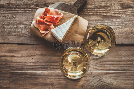 两杯白葡萄酒与布里和普罗西托火腿图片
