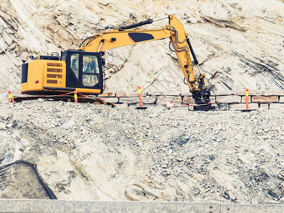 挪威斯堪的纳维亚州在石块建筑工地作业的重型挖掘机推土挪威斯堪的纳维亚州在建筑工地作业的重型机器挪威图片