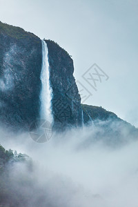 山上瀑布雾雨日美丽的绿色夏季风景旅行和游山地雾日挪威的瀑布图片