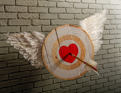 粗木制目标的抽象图像其符号是心脏象征着对灰砖墙的刺穿箭头爱图片