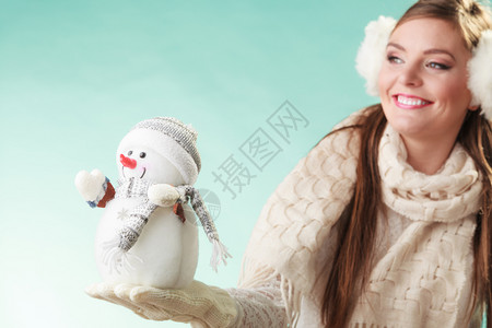 带着小雪人微笑可爱的女人冬天和小雪人微笑着可爱的女人背景图片