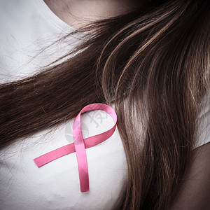 保健医药和乳腺癌认识概念关闭妇女胸腔上的粉色章丝带以支持乳腺癌病因背景图片