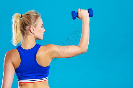 运动女举起轻哑铃重量适合女孩锻炼肌肉健身和美背视合适的女举起哑铃重量背景图片