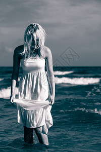 闲暇时间活动年轻女人在沙滩上冷却女士在外面闲逛迷人女孩有白裙子图片