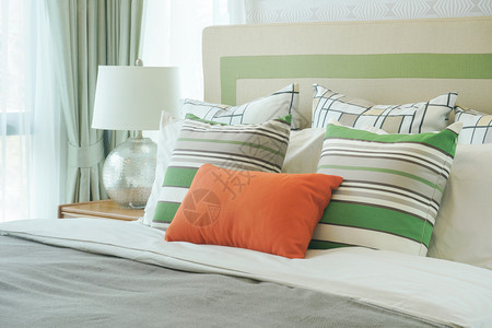 床上有绿色模式枕头的橙图片