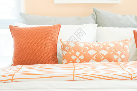 床上橙色和灰的闭合枕头图片