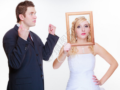 结婚日消极关系概念抱新娘用空相框装扮争吵不力的空相框愤怒新郎和娘持空相框图片