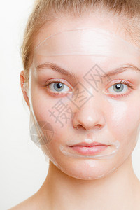 脸部剥皮的年轻女面部剥皮的年轻女肤美容和护理工作室拍摄灰色背景图片