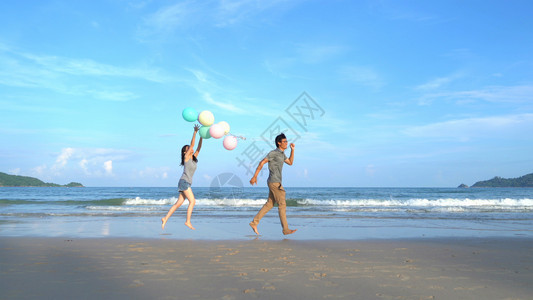 在泰国普吉岛海滩拿着气球玩耍的情侣图片