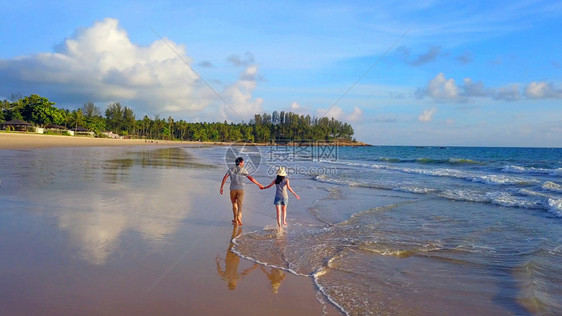快乐的亚洲情侣在海滩上渡蜜月旅行期间在户外度假节日蜜月旅行中约会图片