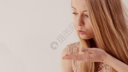 金发长的年轻少女用复制空间在手掌上吹着什么东西图片