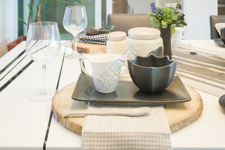 餐桌上的黑白陶器杯架在木制剪板上图片