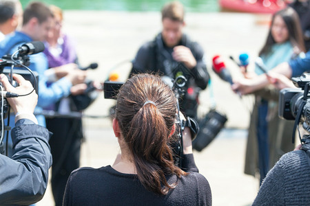 用摄像机拍记者招待会或媒体活动图片