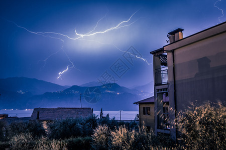在云天山和湖上闪亮建筑在意大利的地平面图片