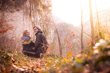 爱的情侣享受着山景美丽的色与日落秋天图片