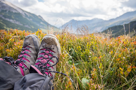 一位穿着远足靴的女人被剪掉她正在享受长山的风景图片