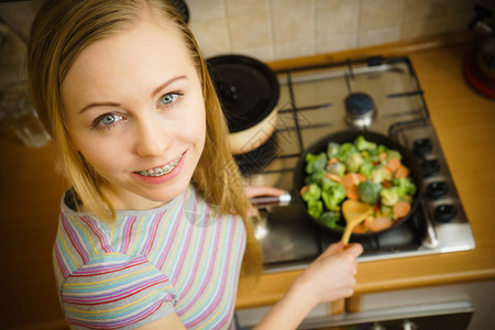 厨艺烹饪中的女子在锅上煎炒冷冻蔬菜在锅上煎煮美味的晚餐食图片