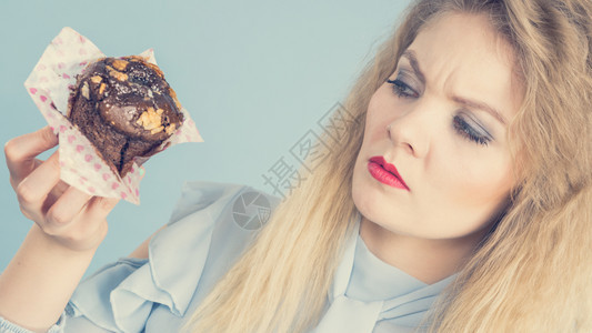 带着深色巧克力味的松饼蛋糕带着深色巧克力味的变态女人在饮食中面部表情令人厌恶图片