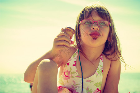 托德勒女孩在海边滩吃冰淇淋年轻女孩在海滩吃冰淇淋图片