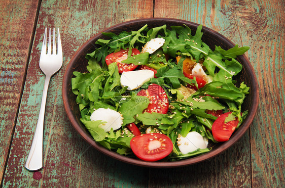 绿色沙拉用青菜番茄芝士马扎里拉球和芝麻盘上做成的绿色沙拉图片