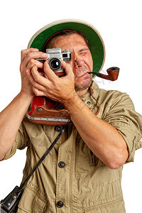 成人旅游者穿着热带软木头盔和防护服嘴里装着管子在旧相机上拍摄一些照片图片