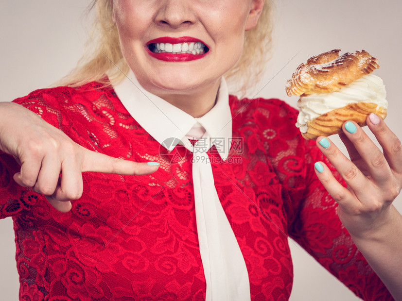 带着奶油味口的怀疑女在饮食中面部表情令人厌恶图片