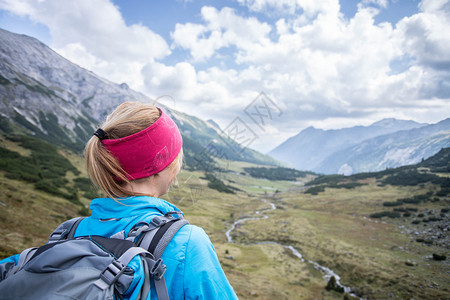 穿运动服和背包的妇女享受山区风景背景图片