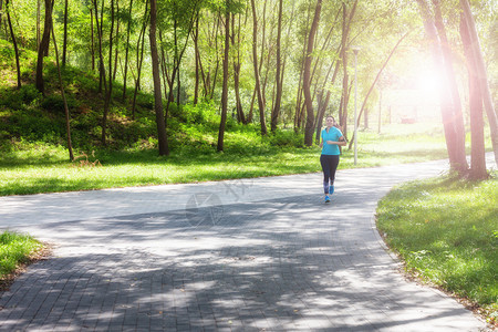 在户外跑的运动健壮女慢跑者在公园步图片