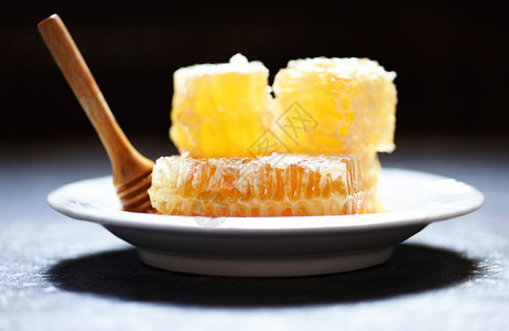 新鲜蜂蜜健康食品黄色甜蜂窝切片白板和黑底有木花图片
