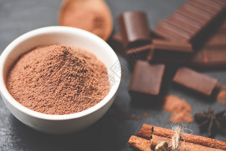 巧克力在碗上的粉和糖果甜点作为零食巧克力棒和暗底香料有选择焦点图片